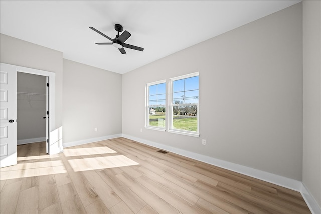 spare room with visible vents, ceiling fan, light wood-style flooring, and baseboards