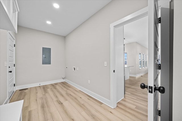 clothes washing area with hookup for an electric dryer, laundry area, baseboards, light wood-type flooring, and electric panel