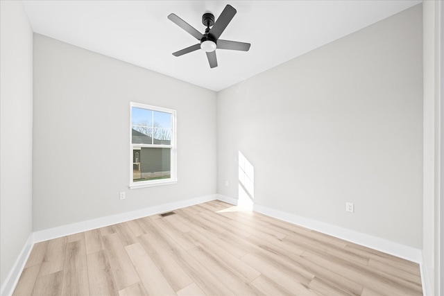 empty room with a ceiling fan, light wood-type flooring, visible vents, and baseboards