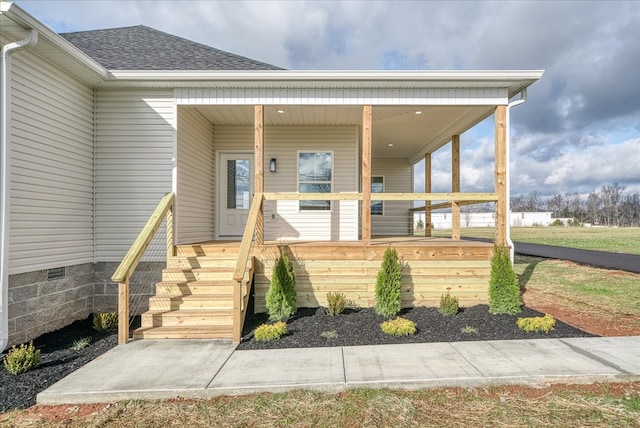 doorway to property with a porch, crawl space, and a shingled roof