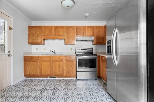 kitchen with under cabinet range hood, stainless steel appliances, a sink, light countertops, and brown cabinetry