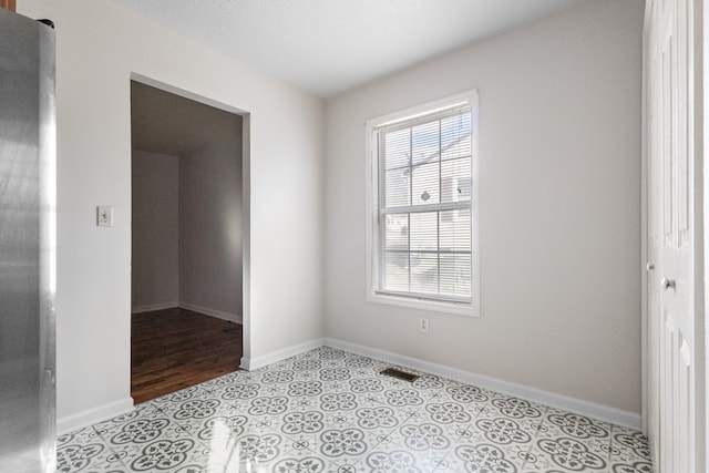 empty room with baseboards and light tile patterned floors