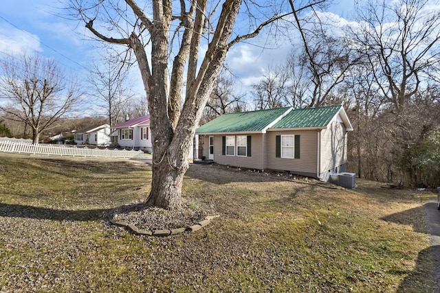 view of front of home with metal roof, a front lawn, fence, and central air condition unit