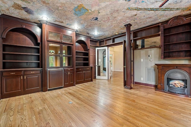 unfurnished living room featuring light wood-type flooring, visible vents, and crown molding