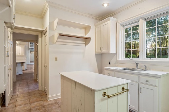 kitchen featuring a sink, light countertops, a kitchen island, and white cabinetry