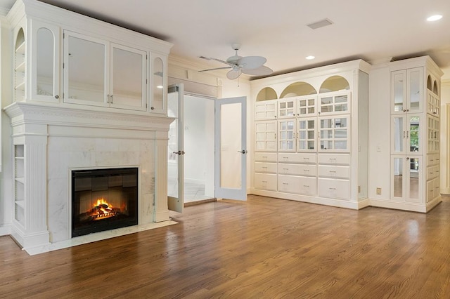 unfurnished living room with ceiling fan, recessed lighting, a premium fireplace, wood finished floors, and baseboards