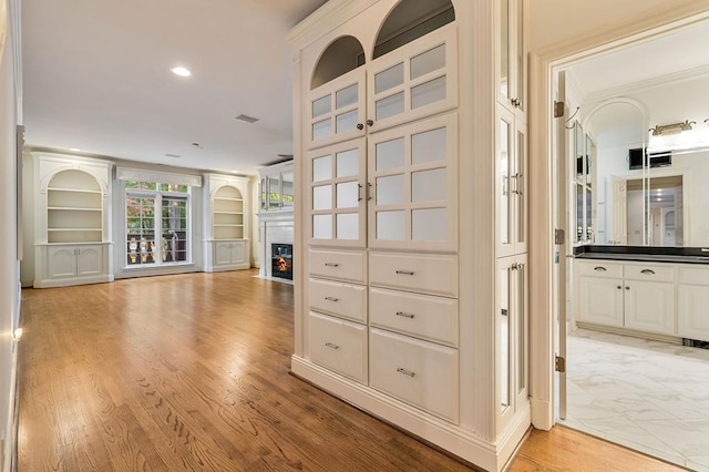 interior space with built in shelves, light wood-type flooring, visible vents, and recessed lighting