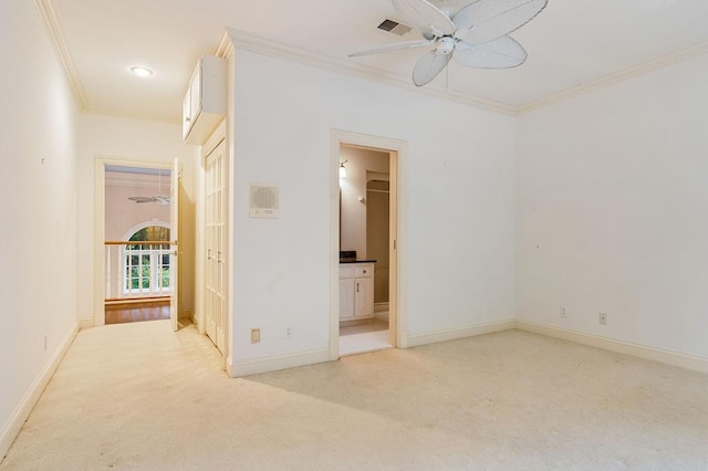 unfurnished bedroom with light colored carpet, visible vents, baseboards, ornamental molding, and ensuite bath