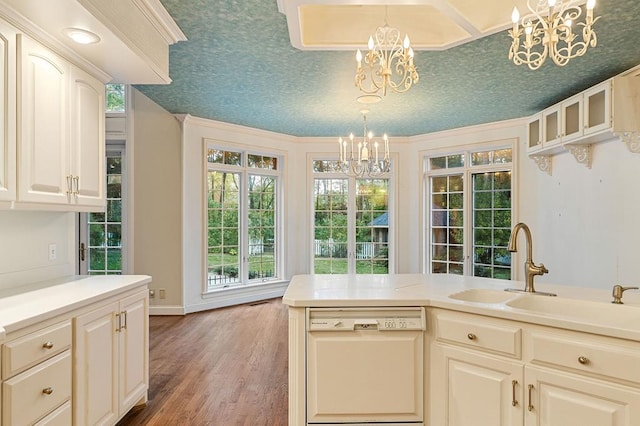 kitchen featuring light countertops, white dishwasher, decorative light fixtures, and an inviting chandelier