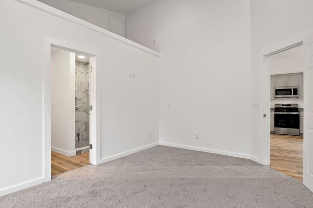 unfurnished room with carpet floors and baseboards