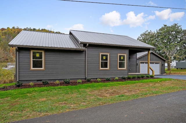 view of front of home featuring a garage, metal roof, a front lawn, and crawl space