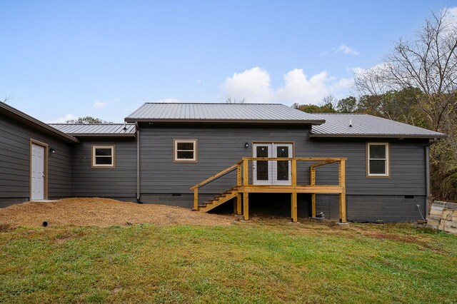 rear view of property featuring crawl space, stairway, metal roof, and a yard