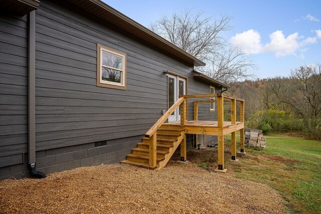 view of home's exterior with a deck, stairway, and crawl space