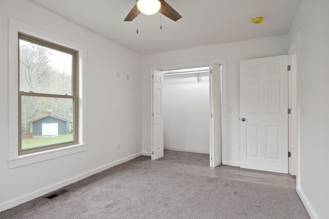 unfurnished bedroom with baseboards, multiple windows, visible vents, and light colored carpet