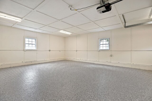 interior space with a wealth of natural light, a paneled ceiling, and speckled floor