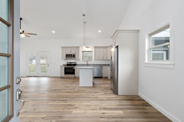 kitchen with white cabinetry, stainless steel appliances, light countertops, and decorative light fixtures