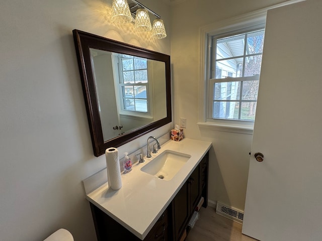 bathroom with a notable chandelier, visible vents, and vanity