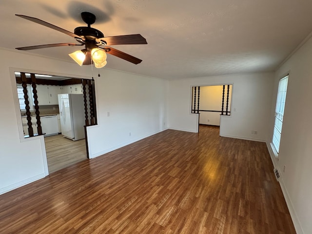 spare room featuring baseboards, ceiling fan, and wood finished floors