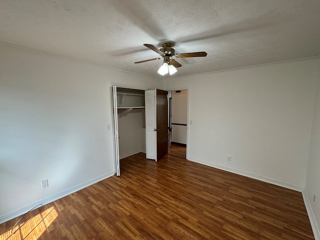 unfurnished bedroom featuring a textured ceiling, wood finished floors, a closet, baseboards, and ceiling fan