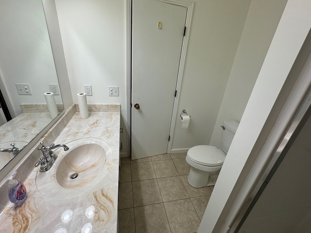 half bathroom featuring tile patterned floors, toilet, and vanity