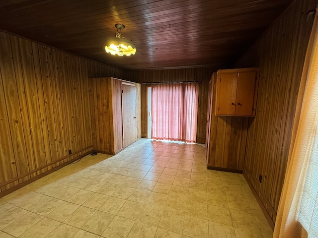 empty room featuring wood walls and wooden ceiling