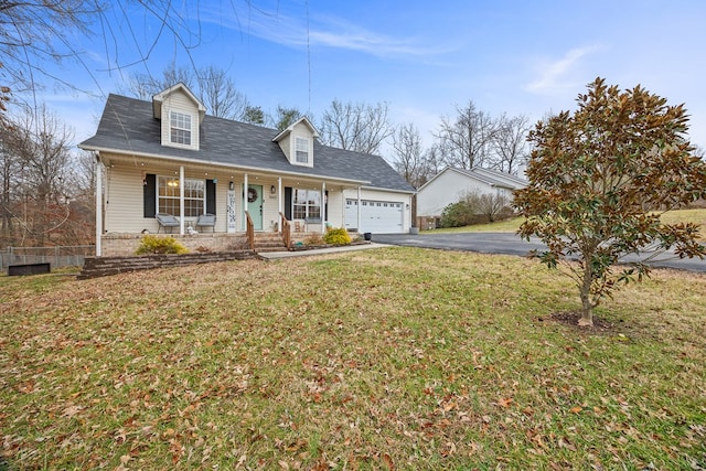 new england style home featuring a porch, a front yard, driveway, and a garage