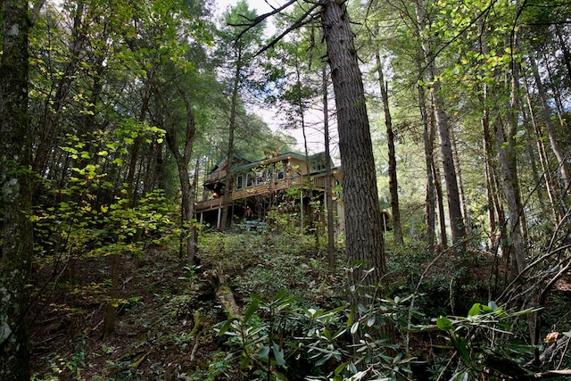 exterior space with a forest view and a deck