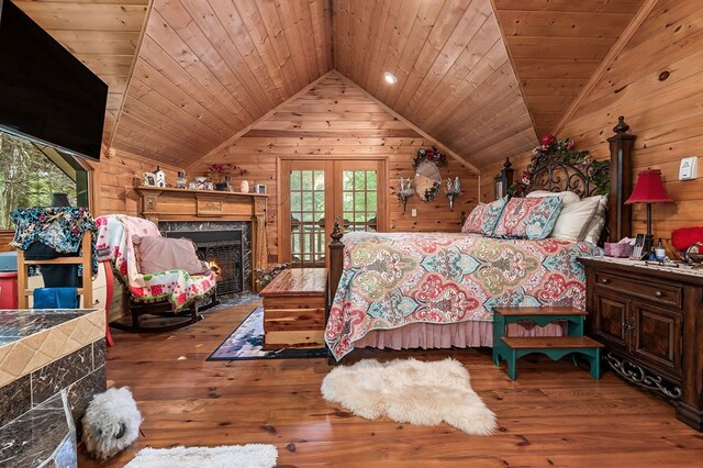 bedroom featuring vaulted ceiling, wooden ceiling, wood finished floors, and wooden walls