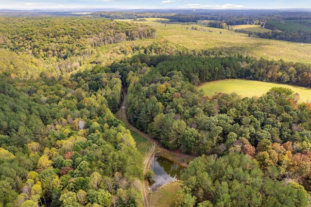 aerial view featuring a forest view and a water view