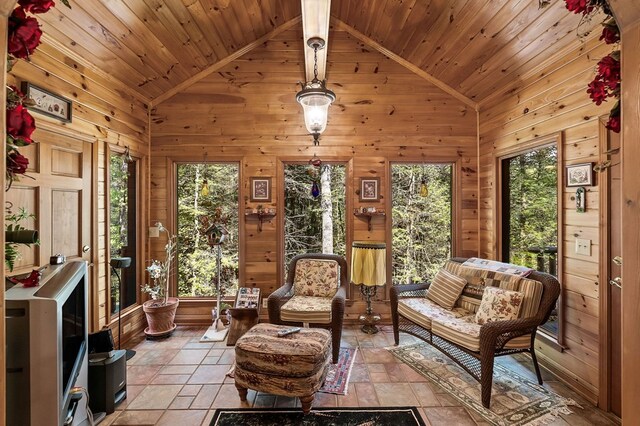 living area with high vaulted ceiling, stone tile flooring, wooden ceiling, and wooden walls