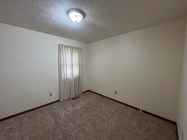 carpeted empty room featuring visible vents, baseboards, and a textured ceiling