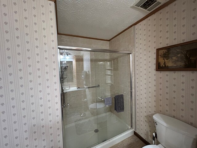 bathroom with wallpapered walls, visible vents, ornamental molding, a textured ceiling, and a shower stall