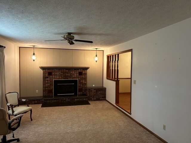 living area with a textured ceiling, a fireplace, a ceiling fan, baseboards, and dark colored carpet