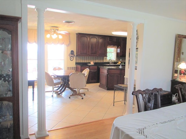 dining area featuring a ceiling fan, light tile patterned flooring, decorative columns, and crown molding