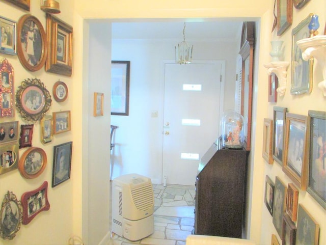 entryway featuring ornamental molding and an inviting chandelier