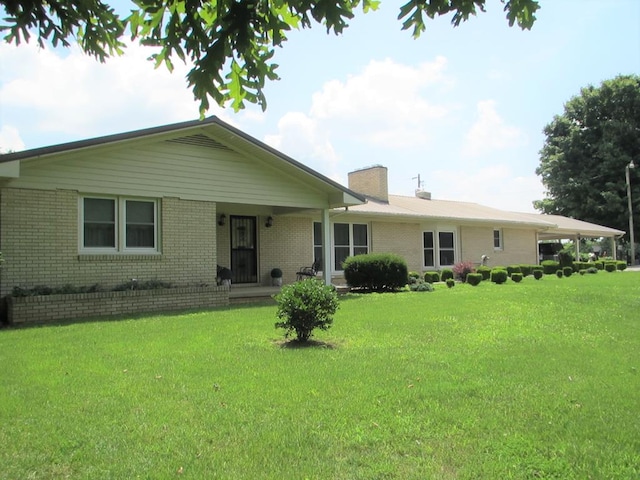 single story home with a front yard, a chimney, and brick siding