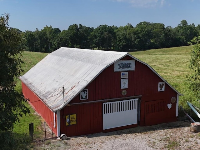 view of barn featuring a yard and a forest view