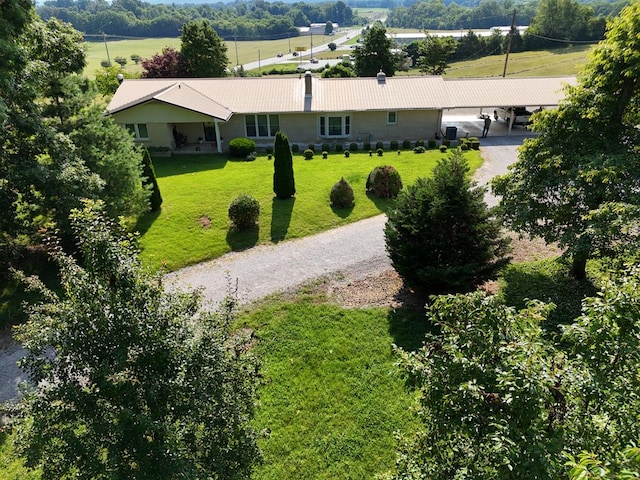 exterior space with a carport, gravel driveway, and a yard