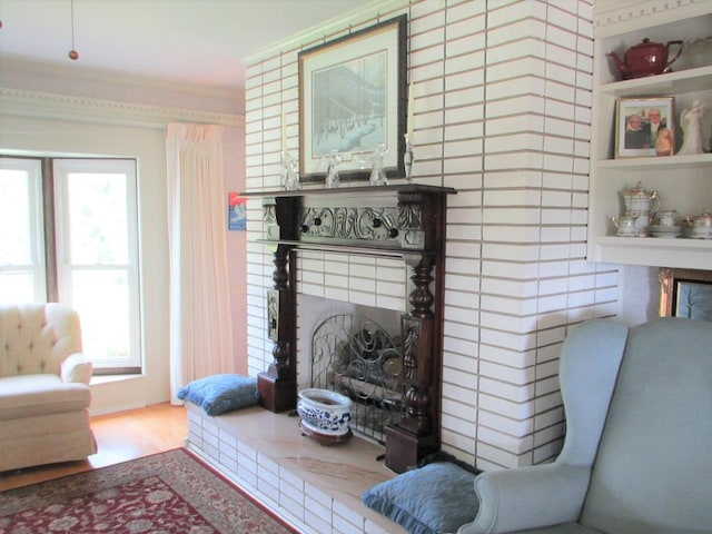 interior space with a brick fireplace and wood finished floors