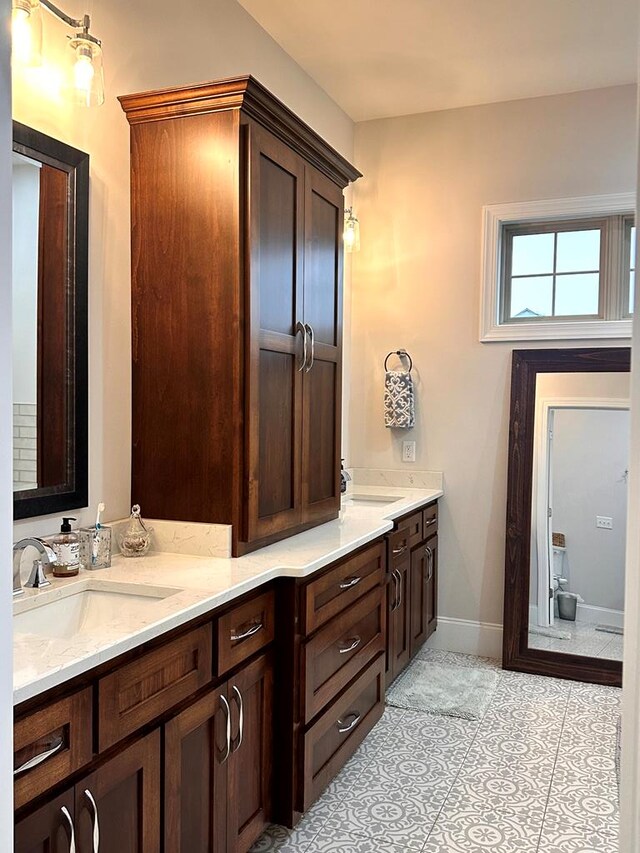 full bathroom with tile patterned flooring, vanity, and baseboards