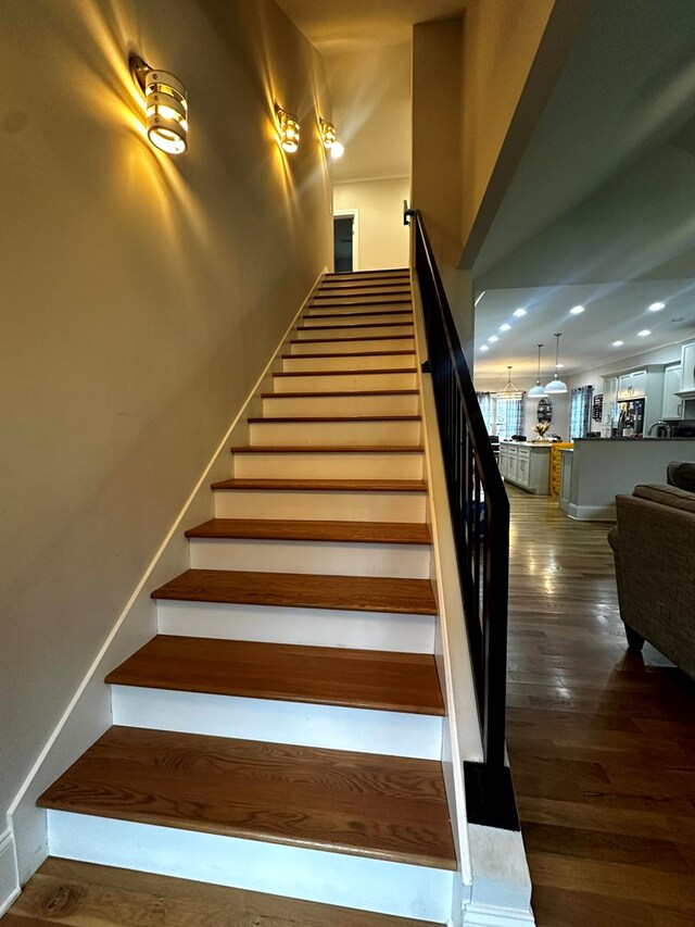 staircase with recessed lighting, wood finished floors, and baseboards