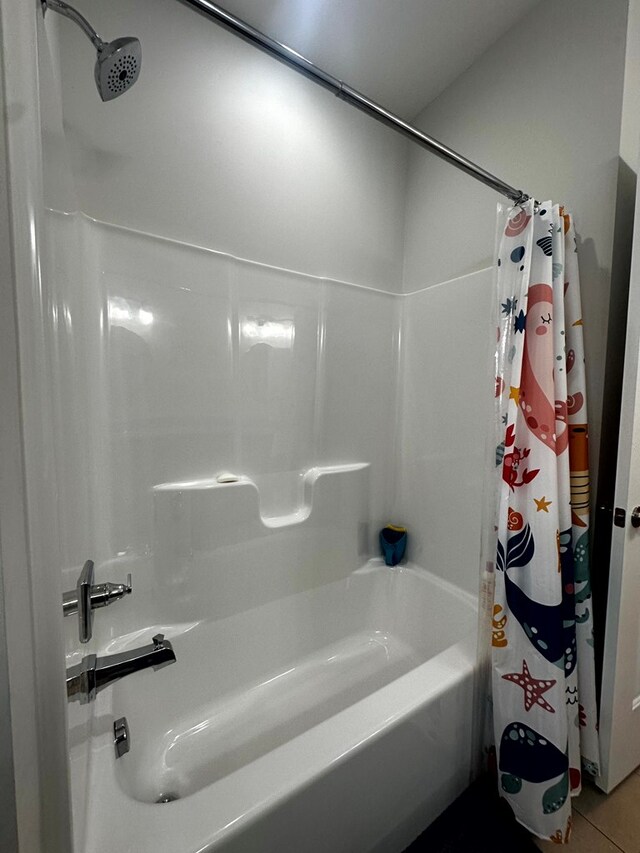 bathroom with tile patterned flooring and shower / bathtub combination with curtain