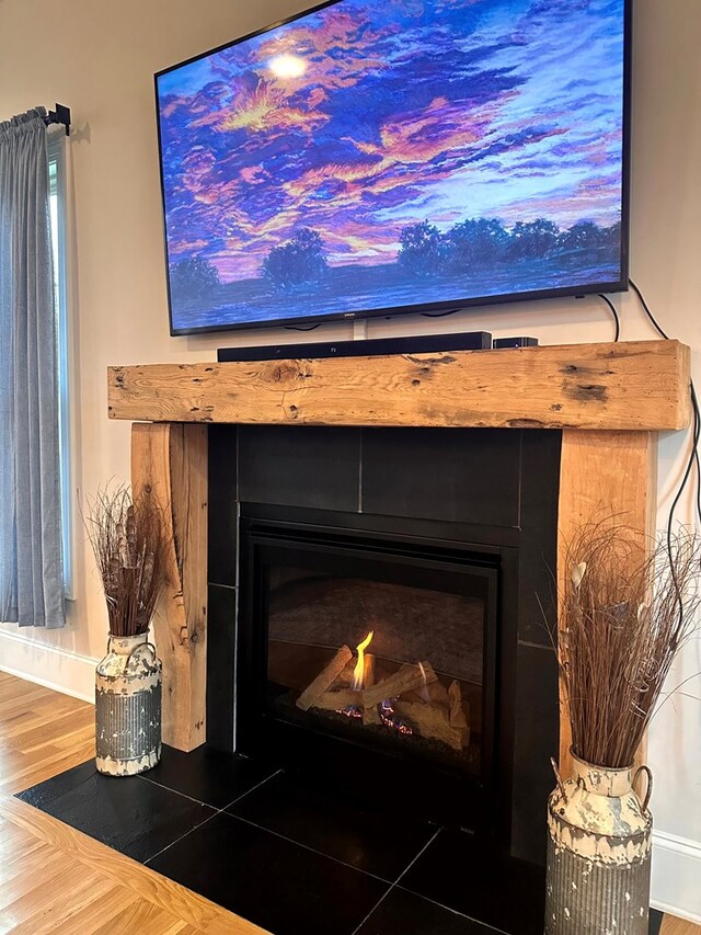 interior details with a fireplace with flush hearth and wood finished floors