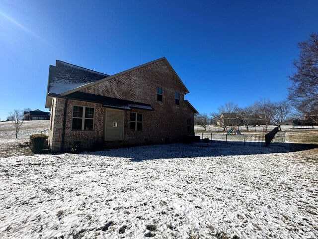 view of property exterior featuring brick siding and fence