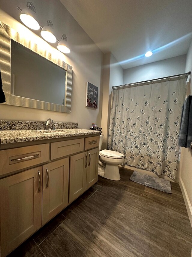 full bathroom with toilet, curtained shower, wood finished floors, and vanity