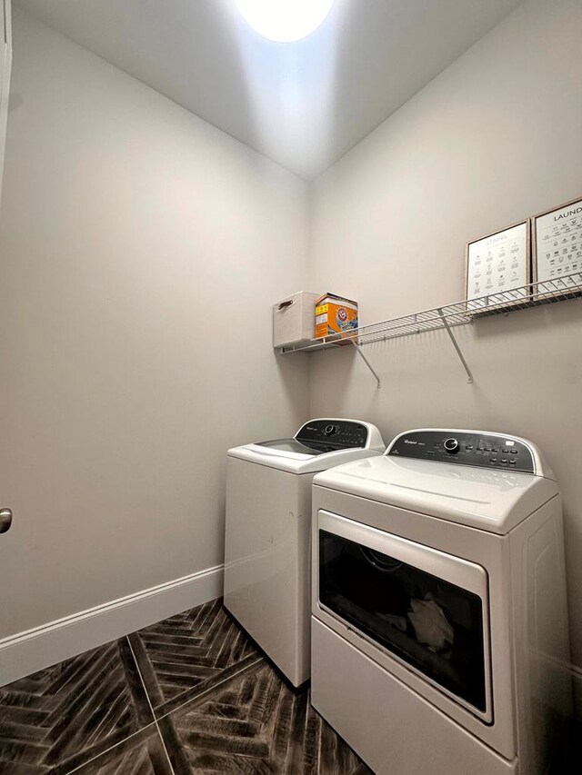 clothes washing area with laundry area, baseboards, and separate washer and dryer