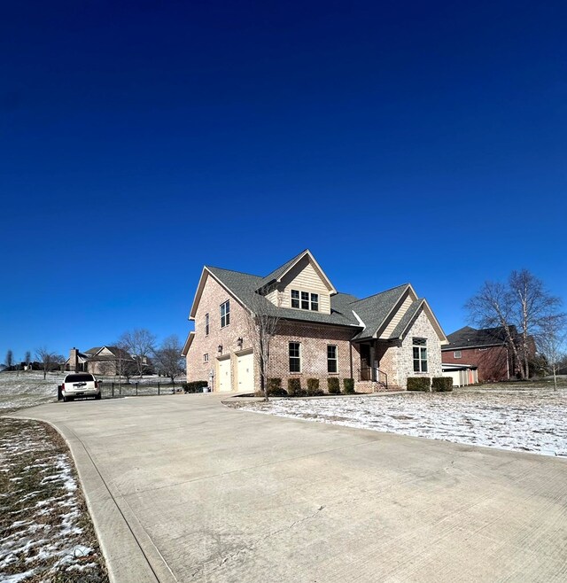 view of front facade with an attached garage, fence, and concrete driveway