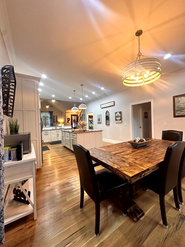 dining area with lofted ceiling, light wood-style flooring, and recessed lighting