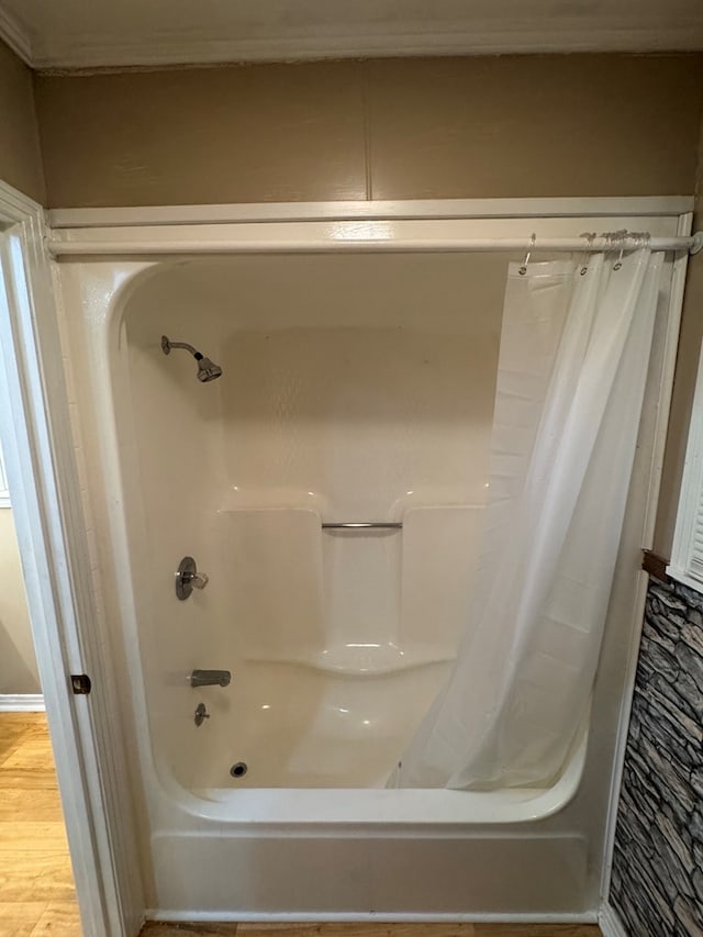 full bath with shower / bathtub combination with curtain and wood finished floors