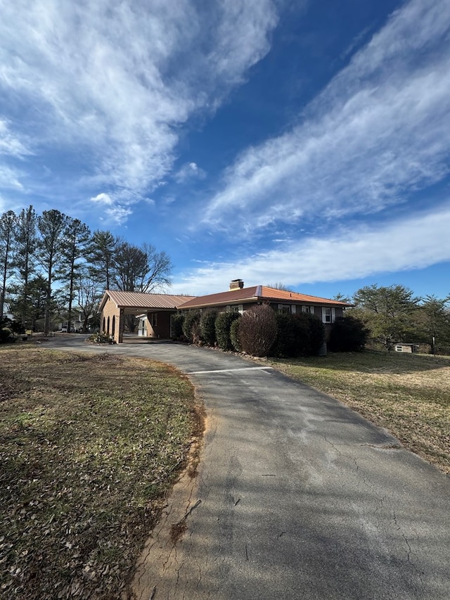 ranch-style home with aphalt driveway and a front yard